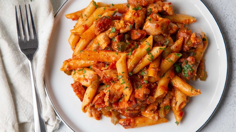 pasta with tomato sauce and parsley on a white plate