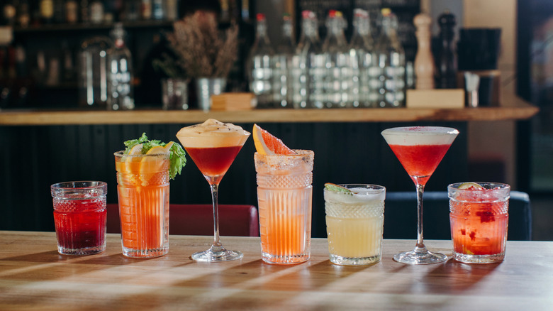 A lineup of different cocktails on a bar top