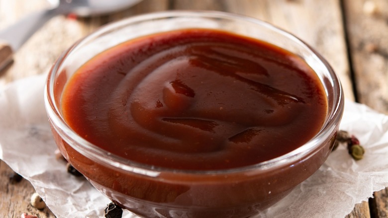 A clear glass bowl of barbecue sauce isolate on a white background
