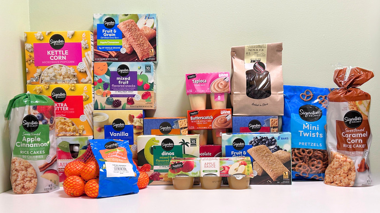 Many Signature Select snacks on a white and green background