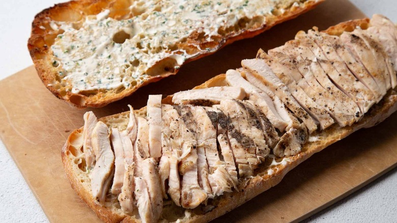 Toasted bread covered in creamy dressing and chopped chicken