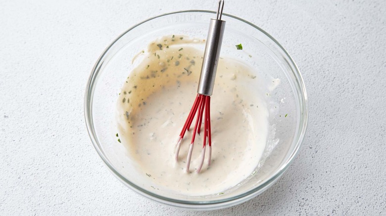Creamy salad dressing in a clear bowl