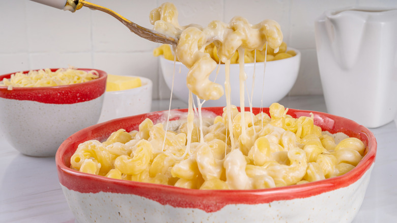 Creamy macaroni and cheese with ingredients in the background