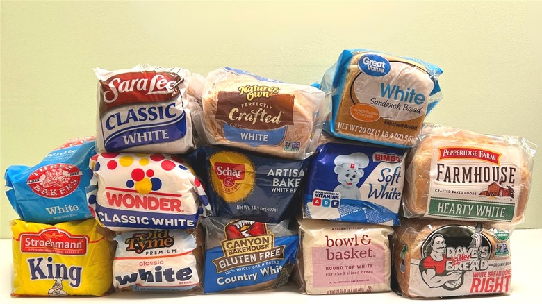 Stack of different brands of store-bought white bread loaves