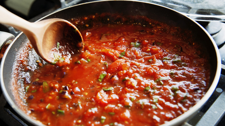 stirring pasta sauce in skillet